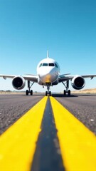 Obraz premium Airplane on runway with clear blue sky and yellow lines, showcasing aviation technology and travel experience, flight preparation concept