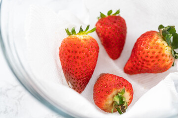 Fresh and Moldy Strawberries in a Glass Bowl on a White Napkin
