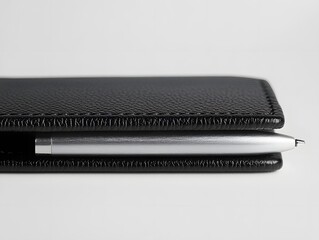 Classic Black Leather Notebook with Silver Pen on White Background