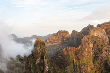 Rocky mountain peaks emerging through morning clouds in Madeira, Portugal