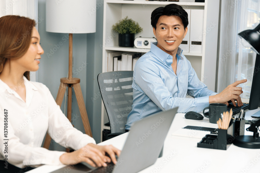 Poster smiling asian man talking with woman colleague in planning marketing report project on laptop casual