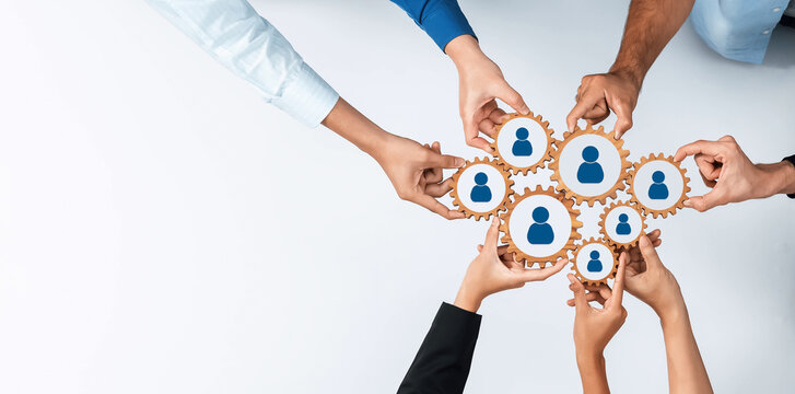 This image illustrates a collaborative networking concept, showcasing diverse hands connecting gears and people icons, symbolizing teamwork and unity in a modern business environment. Amity