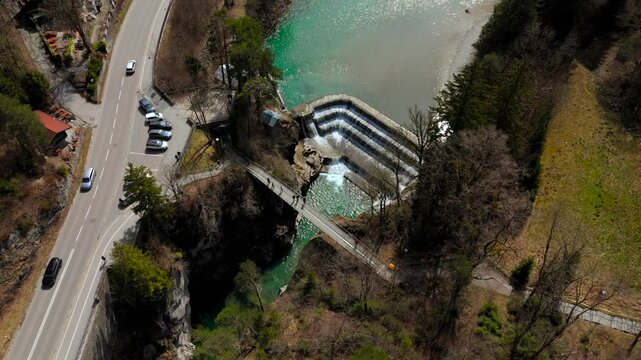 A breathtaking aerial view of Lechfall in Fussen, Germany. The turquoise waters cascade over the dam, surrounded by rugged cliffs and lush forests. A must-visit natural wonder in the Bavarian Alps