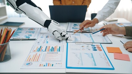 Human team collaborates with a robotic assistant on data analysis and strategy planning, showcasing the integration of technology in modern business environments.Noogenesis