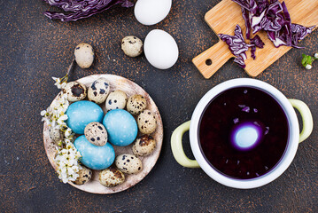 Process of painting Easter eggs in blue