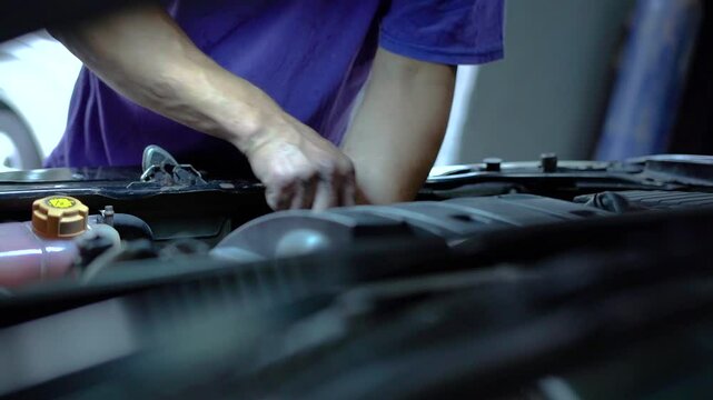 Mechanic's hands adjust the engine