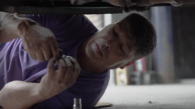 mechanic adjusting the chassis of a car. Inspection