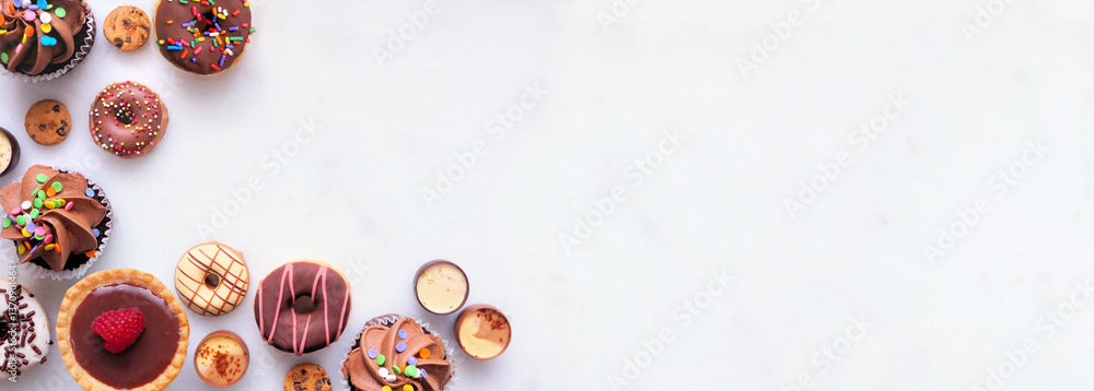 Aufkleber dessert corner border with an assortment of sweets. top view on a white stone banner background with