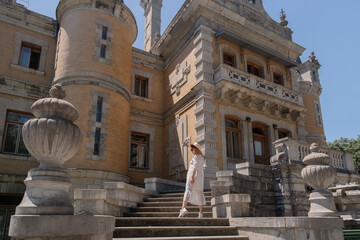 A woman stands on a set of stairs in front of a large building