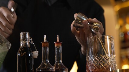 Closeup hand bartender holding jigger to measure liquor sugar into mixing glass ingredients alcohol preparation creative mixed cocktail. Special refresh drink showcasing nightlife mixology. Vinosity.