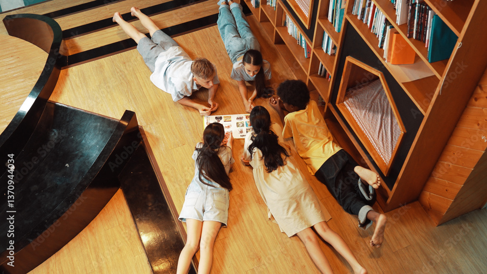 Poster group of diverse children lying down in circle while reading a book at library. top view of girl sha