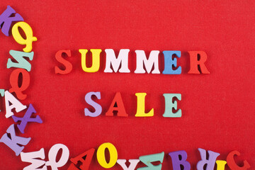 Summer sale word on red background composed from colorful abc alphabet block wooden letters, copy space for ad text. Learning english concept.