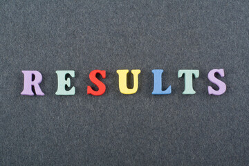 RESULTS word on black board background composed from colorful abc alphabet block wooden letters, copy space for ad text. Learning english concept.