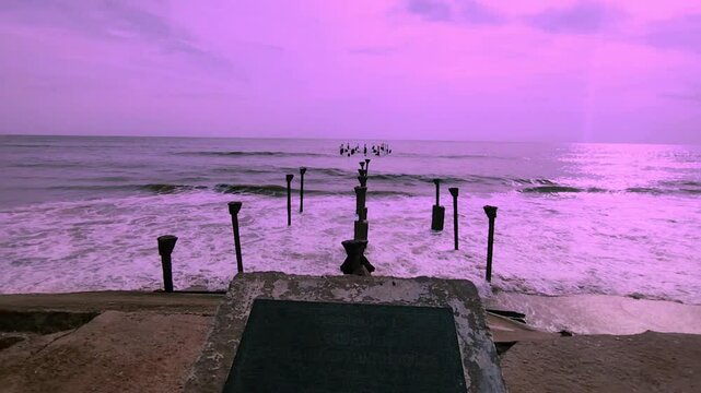 Ocean view in Kozhikode Kerala India broken iron bridge legs on ocean waves hitting the shore