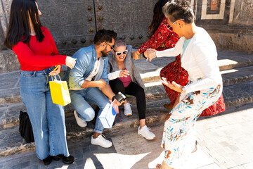Obraz premium Happy tourists showing new purchases and having fun on city steps