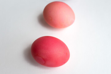 Easter eggs in purple and pink shades are lying on a white background with a shadow photo