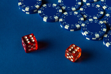 Colorful red dice sit near stacks of blue poker chips on a bright blue table, creating an inviting atmosphere for a game night among friends. Excitement fills the air as players prepare