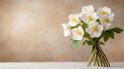 A charming bouquet of white flowers tied together with lush green stems, presented on a soft fabric surface, radiating freshness and a touch of elegance.