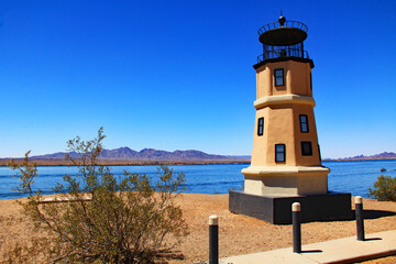 Replica of the Split Rock lighthouse in Lake Havasu City, Arizona, USA on lake Havasu with blue sky copy space and California mountains.