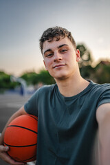One caucasian teenager stand on basketball court with ball