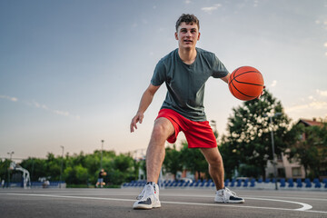 One caucasian teenager stand on basketball court with ball
