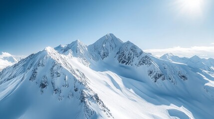 Snow covered mountains pierce a clear blue sky