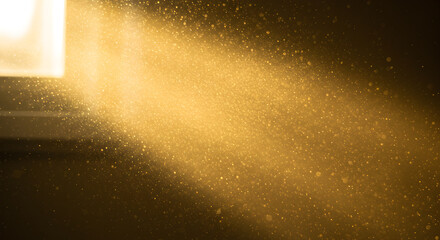 Golden light beam illuminating floating particles against a dark background