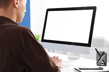 Man working on computer at white desk in office, closeup. Mockup for design