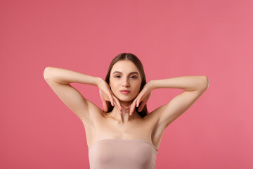 Young woman showing smooth skin after epilation on pink background