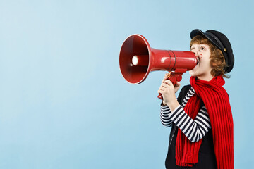 Cute boy in mime costume shouting in megaphone on light blue background, space for text. Surprise...
