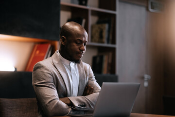 Stress, burnout and business black man at night working on project, report and strategy deadline. Headache, mental health and male in dark office frustrated, tired and work problem on computer