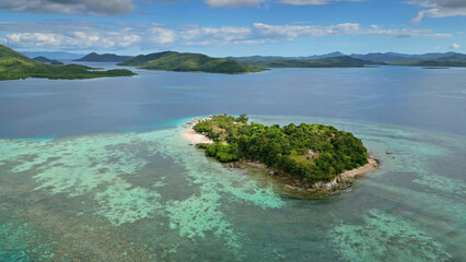 Fototapeta premium Small tropical island surrounded by distant islands