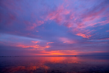 Vibrant sunset over the calm sea reflecting colorful skies