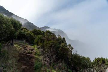 A panoramic mountain view with peaks covered in light clouds.
