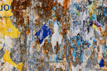 Muro con ruggine e manifesti strappati
