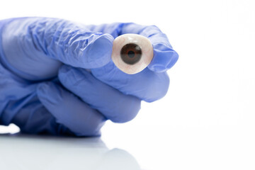 Ocularist holding ocular prosthesis for eye implant surgery