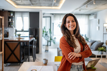 Confident businesswoman smiling with crossed arms in her modern home office