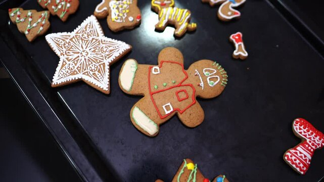 Decorated with colored icing Christmas gingerbread cookies lie on a baking sheet