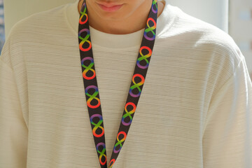 Teenage boy with autism acceptance lanyard. Black neck strap lanyard with infinity symbols