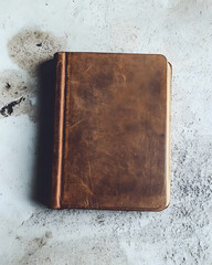 An aged leather journal rests on a textured surface, inviting imagination and reflection.