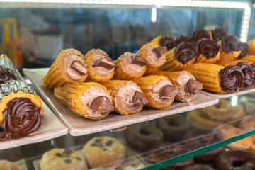 A display case filled with a variety of pastries and donuts