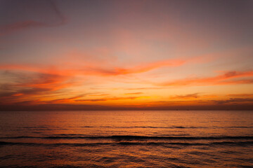 Beautiful bright stunning romantic sunset or sunrise on the horizon of clouds and the turbulent Black Sea of ​​the Krasnodar Territory in the tourist village of Anapa.