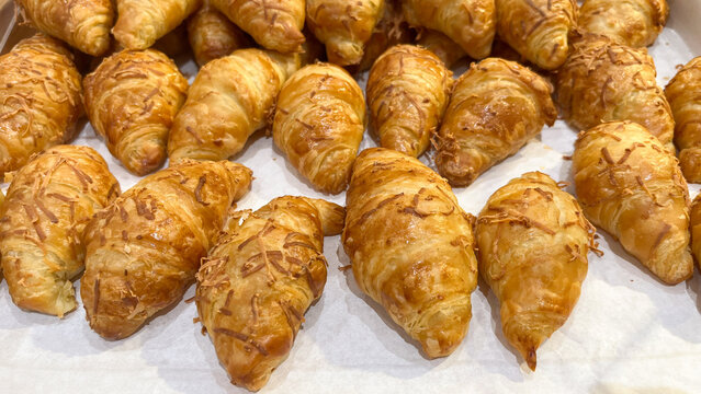 Cheese croissants on display in a bakery display case