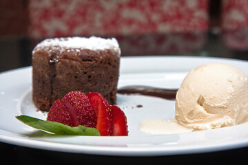 Delicious chocolate fondant with strawberry, chocolate sauce and walnut ice cream, desserts