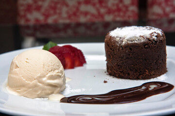 Delicious chocolate fondant with strawberry, chocolate sauce and walnut ice cream, desserts