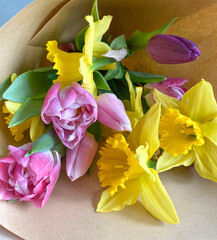 Перейти к странице
|12345...11Далее
Beautiful composition of the first spring flowers with green leaves in a bouquet. Yellow daffodils, pink tulips in a bouquet on craft paper, top view.