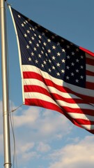 American flag waving against a clear blue sky during daylight hours, showcasing patriotism and national pride