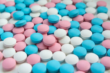 White, blue and pink tablets scattering on the table