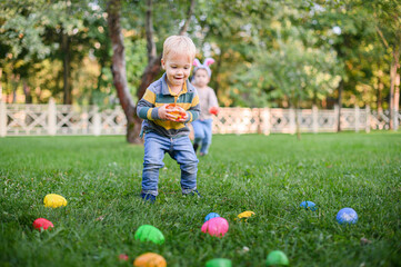 Children Hunting Easter Eggs in the Garden with Bunny Ears
