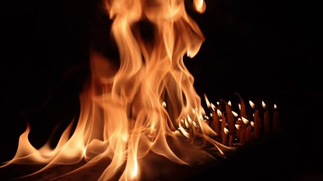 Burnng candles shot in slow motion - and a large fire burnign in the fore ground